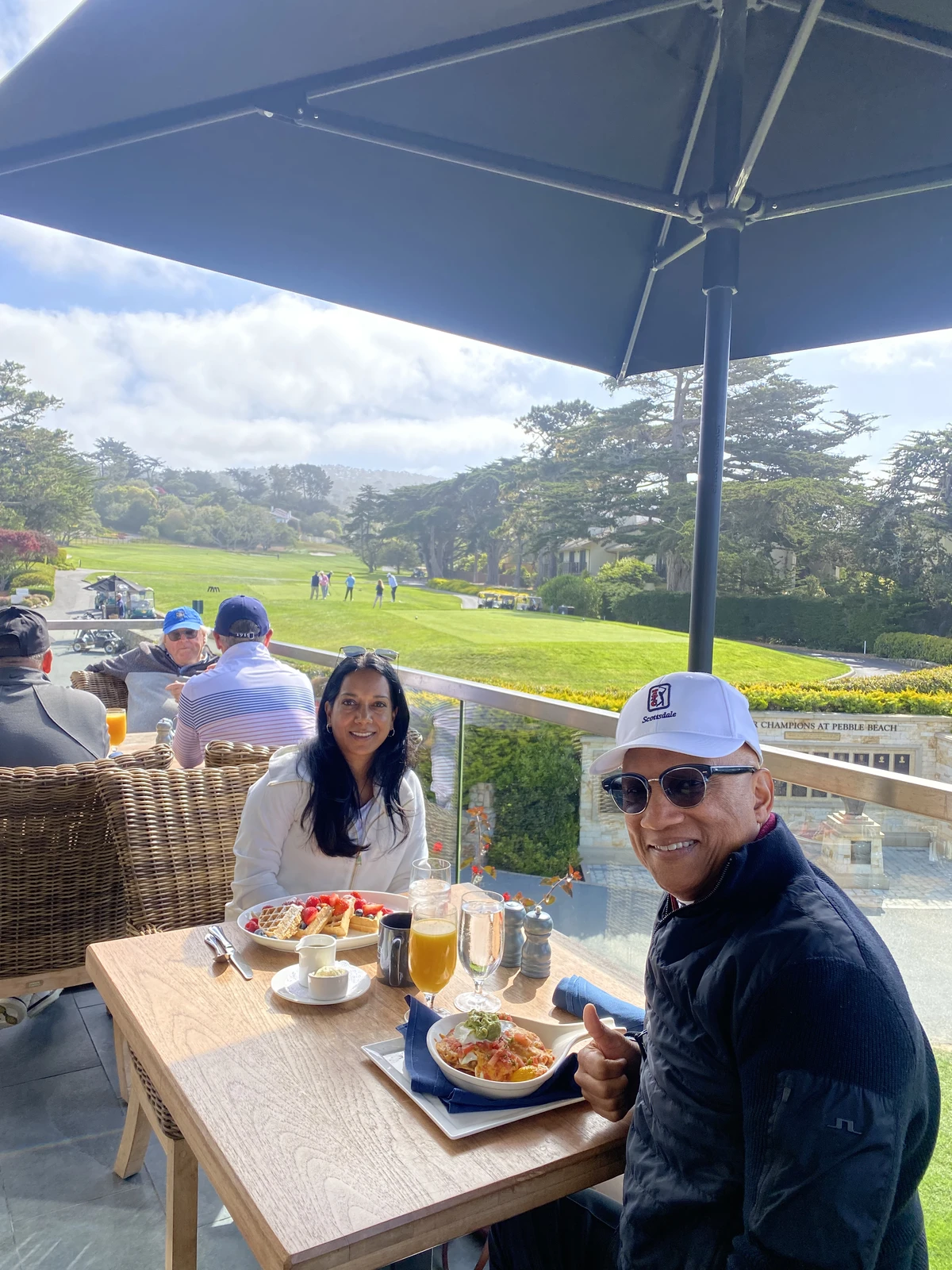 Group dining on the terrace at Pebble Beach with views of the fairway