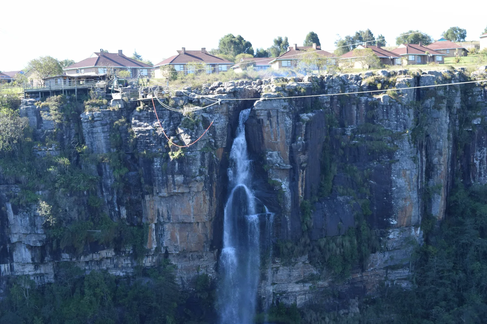 A waterfall below cliffside lodges